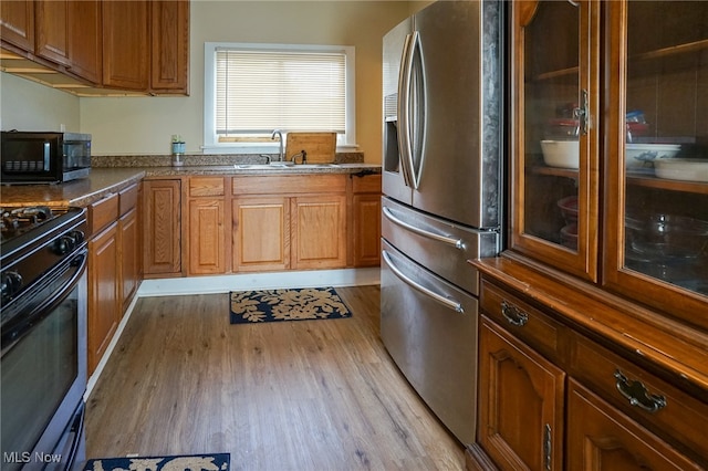 kitchen featuring appliances with stainless steel finishes, light hardwood / wood-style floors, and sink