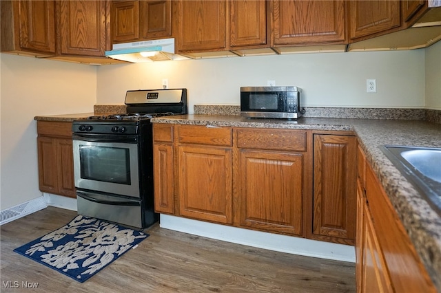 kitchen featuring dark wood-type flooring and stainless steel appliances