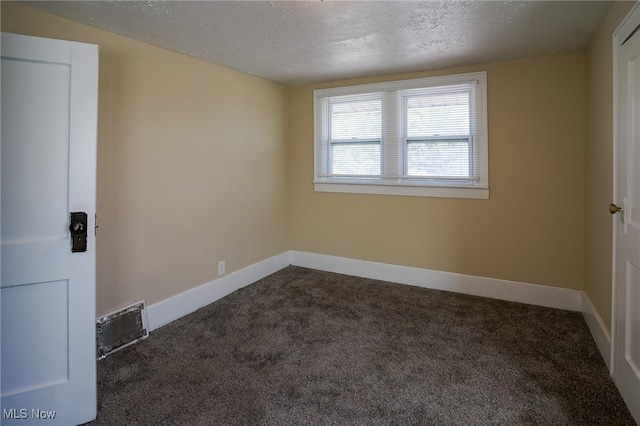 carpeted empty room with a textured ceiling