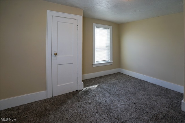 empty room with a textured ceiling and carpet floors