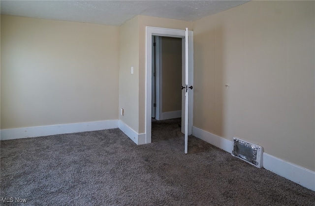 spare room featuring a textured ceiling and carpet