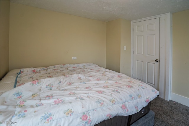 carpeted bedroom with a closet and a textured ceiling