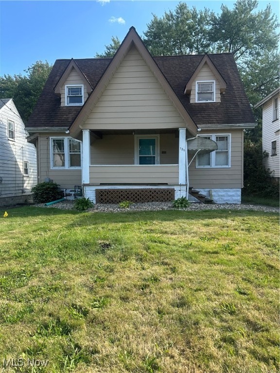 new england style home with a front yard and covered porch