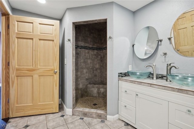 bathroom featuring vanity, a tile shower, and tile patterned floors