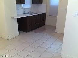 kitchen featuring sink, light tile patterned floors, and dark brown cabinets