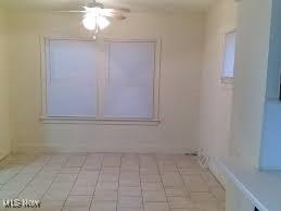 unfurnished room with ceiling fan and light tile patterned flooring