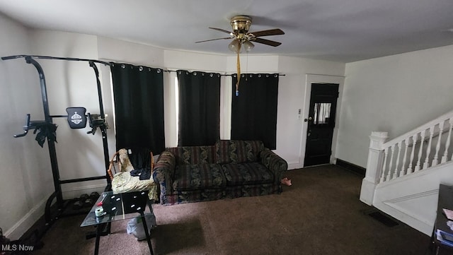 interior space with dark carpet and ceiling fan