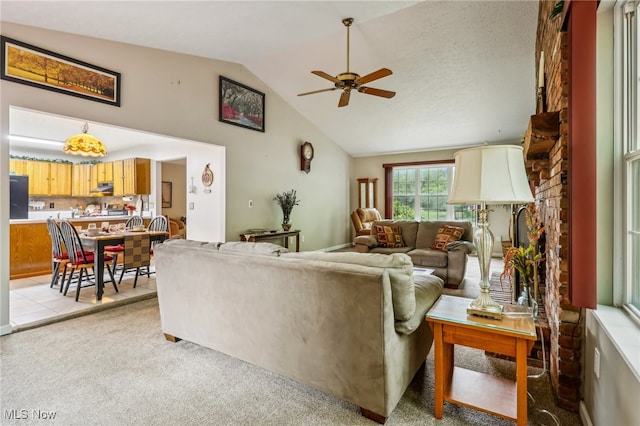 carpeted living room with ceiling fan and lofted ceiling