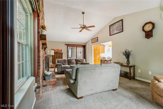 living room with ceiling fan, carpet floors, a wealth of natural light, and vaulted ceiling