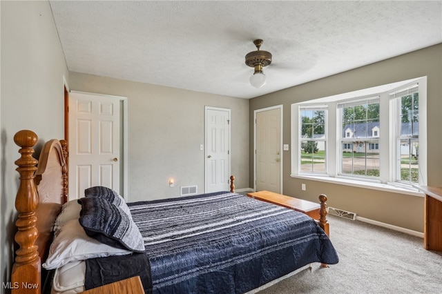 bedroom featuring a textured ceiling, carpet floors, and ceiling fan