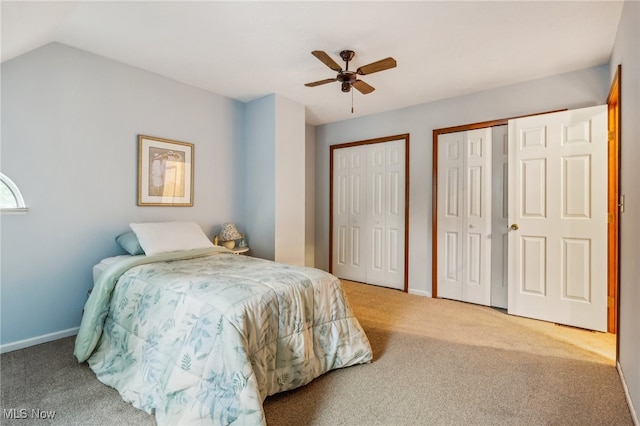 bedroom featuring two closets, ceiling fan, carpet, and lofted ceiling