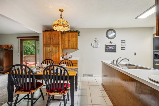 dining area with sink, light tile patterned flooring, and a textured ceiling