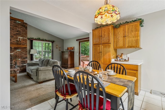 tiled dining room featuring a textured ceiling and vaulted ceiling