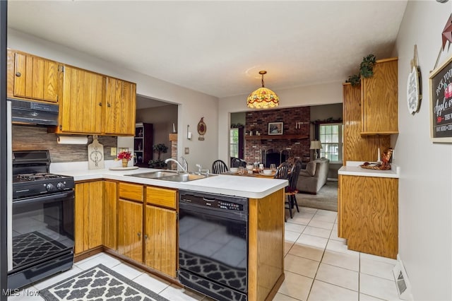 kitchen with sink, a brick fireplace, range hood, kitchen peninsula, and black appliances