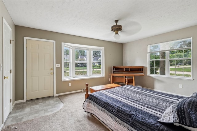 bedroom with ceiling fan, a textured ceiling, and multiple windows