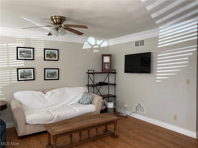 living room featuring ornamental molding, ceiling fan, and dark hardwood / wood-style floors