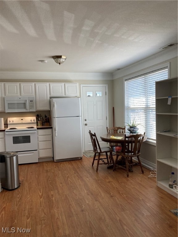 kitchen with crown molding, white cabinetry, white appliances, light hardwood / wood-style flooring, and a textured ceiling