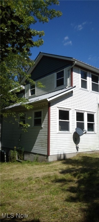 view of side of home featuring a lawn