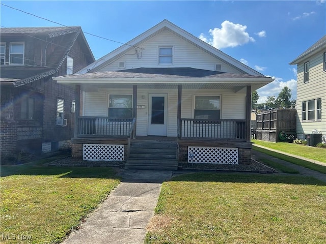 bungalow-style home with a front yard, a porch, and central AC