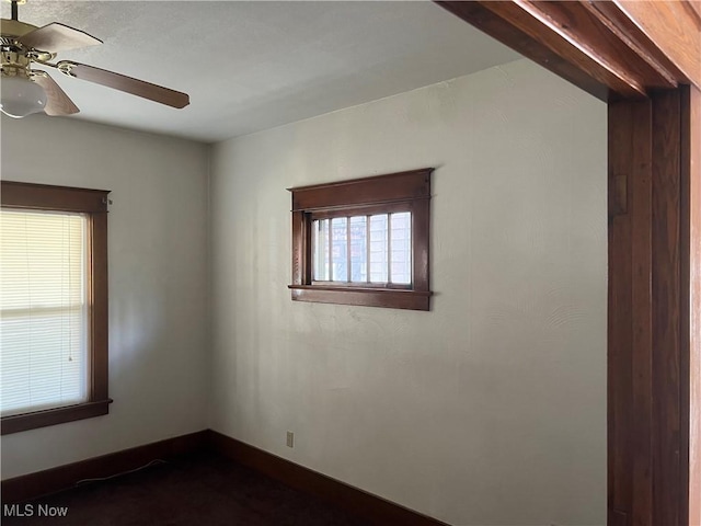 spare room with baseboards and ceiling fan