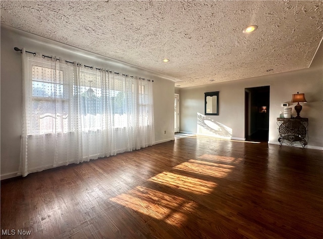 unfurnished living room featuring dark wood-type flooring and a textured ceiling