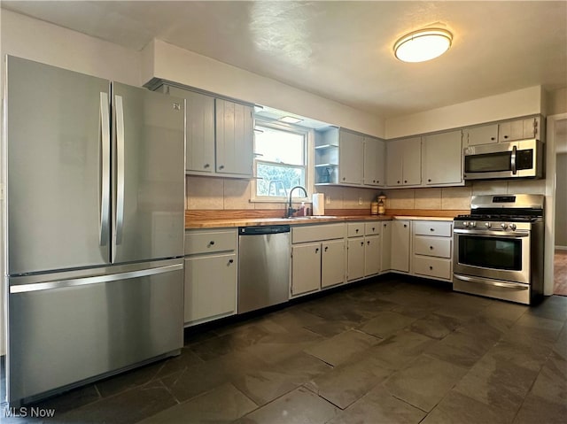 kitchen featuring appliances with stainless steel finishes, sink, and decorative backsplash