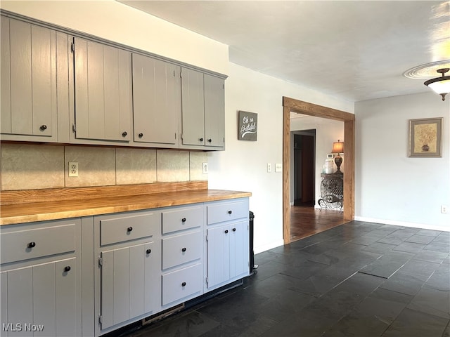 kitchen with gray cabinets, backsplash, and butcher block countertops