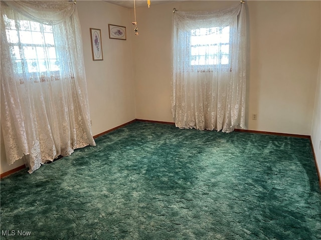 unfurnished room with dark carpet