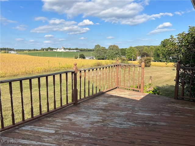 wooden terrace with a lawn and a rural view