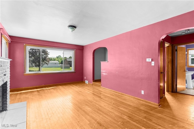 unfurnished living room with light wood-type flooring and a fireplace