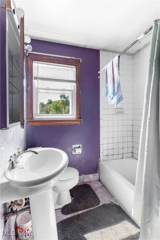 bathroom featuring toilet and shower / bath combo with shower curtain