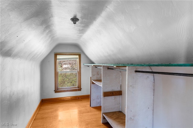 bonus room featuring lofted ceiling and light hardwood / wood-style flooring