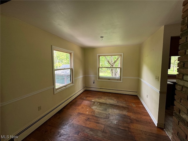 empty room featuring dark hardwood / wood-style flooring and baseboard heating