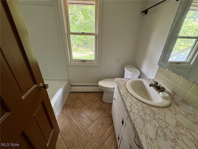 full bathroom featuring toilet, baseboard heating, and a wealth of natural light