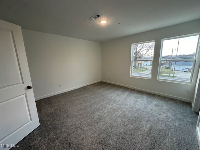 empty room featuring dark carpet