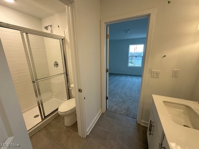 bathroom with walk in shower, tile patterned flooring, vanity, and toilet