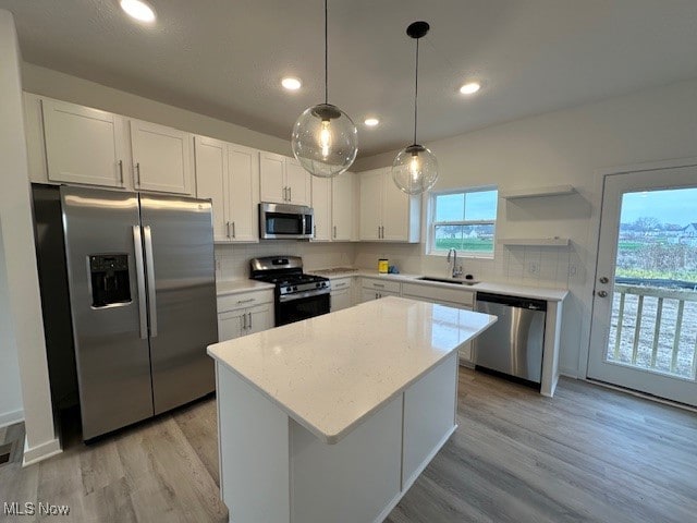 kitchen featuring white cabinetry, sink, stainless steel appliances, and light hardwood / wood-style flooring