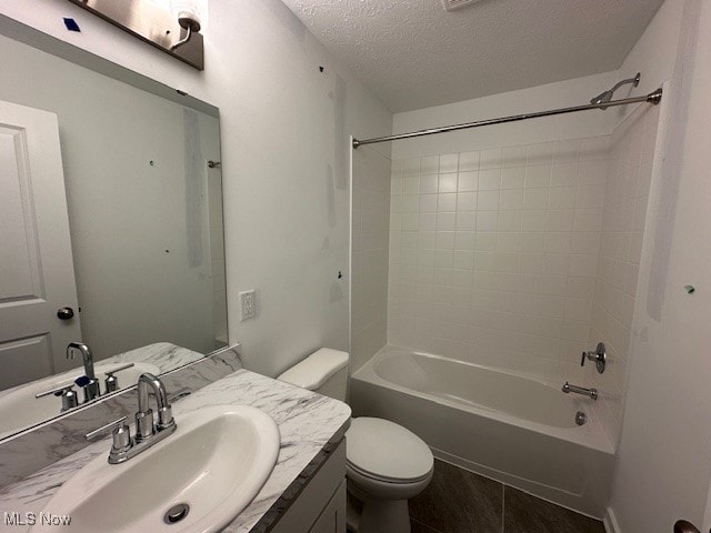 full bathroom with shower / tub combination, vanity, a textured ceiling, and toilet