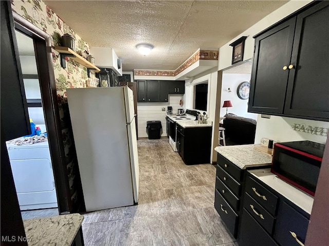 kitchen with washer / dryer, white appliances, and a textured ceiling