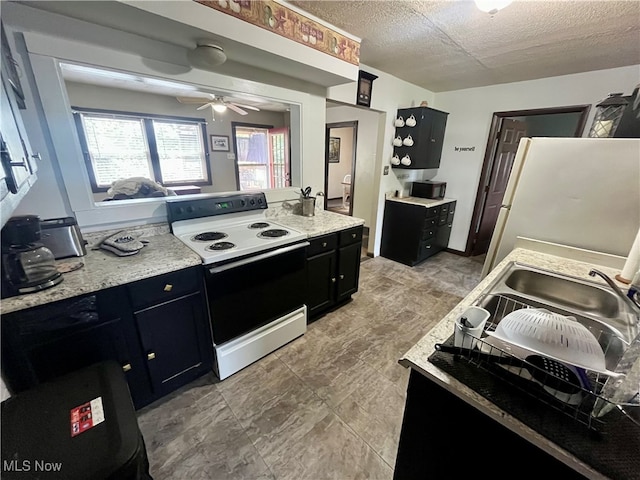 kitchen with white appliances, ceiling fan, and a textured ceiling