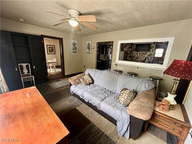 carpeted living room featuring a textured ceiling and ceiling fan