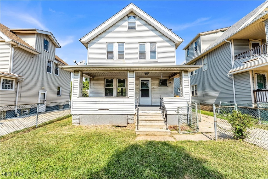 view of front of home with a balcony, covered porch, and a front yard