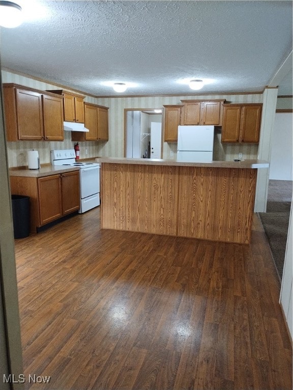 kitchen featuring dark wood-type flooring, white appliances, and a textured ceiling