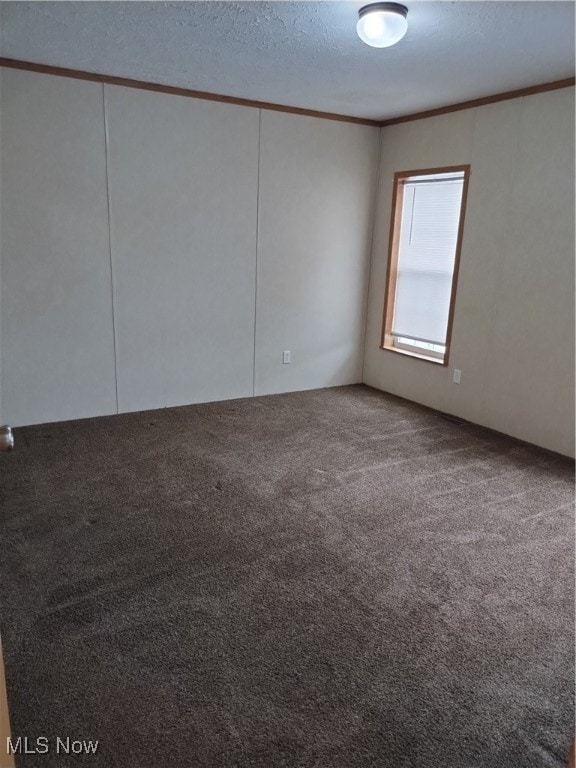 empty room with ornamental molding, a textured ceiling, and carpet flooring