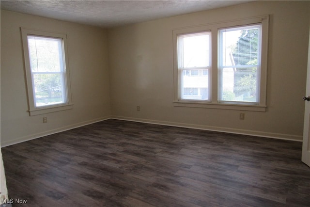 spare room with dark hardwood / wood-style flooring and a textured ceiling