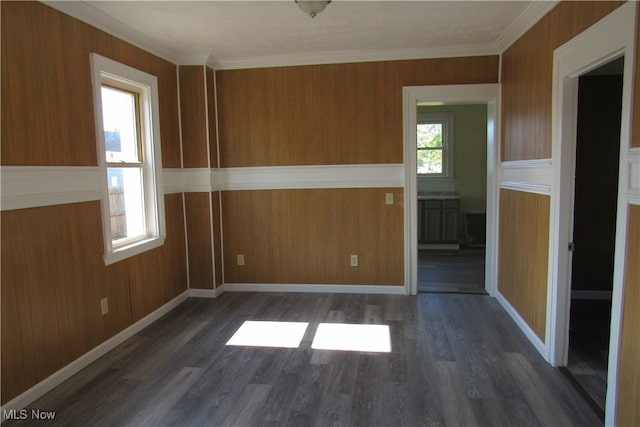 unfurnished room featuring ornamental molding, wooden walls, and dark hardwood / wood-style floors