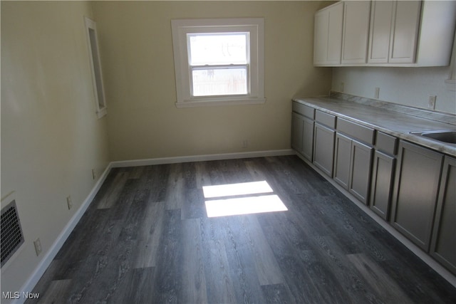 kitchen featuring gray cabinetry and dark hardwood / wood-style floors