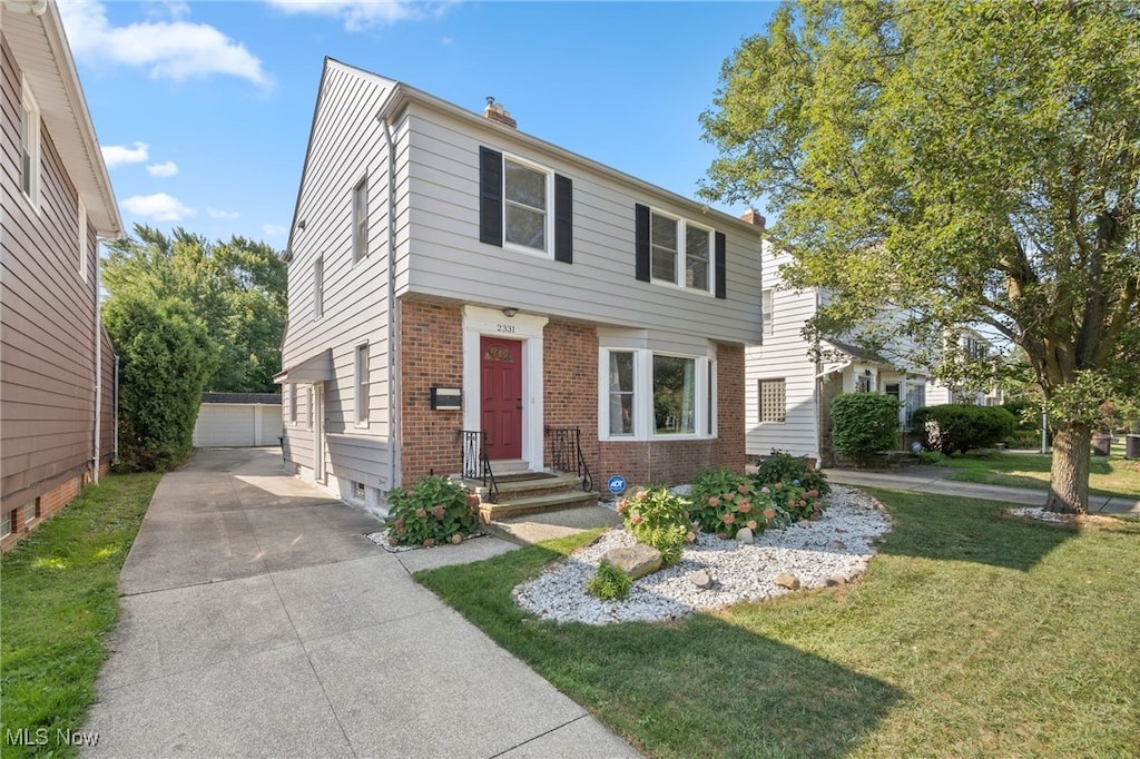 view of front of house with an outdoor structure, a garage, and a front lawn