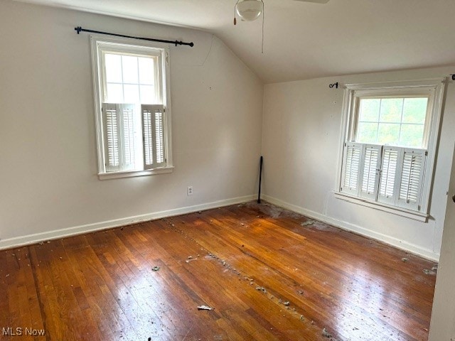 empty room featuring lofted ceiling, ceiling fan, and dark hardwood / wood-style flooring