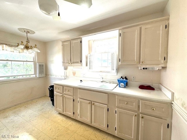 kitchen featuring decorative light fixtures, a notable chandelier, and sink